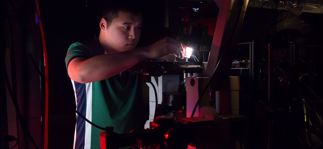 Albert Lin working on a microscope in Aravi Samuel's lab