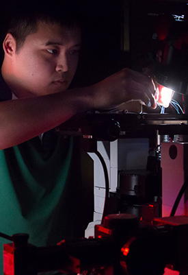 Albert Lin working on a microscope in Aravi Samuel's lab
