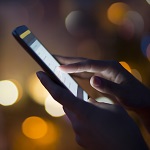 Woman using her mobile phone , city skyline night light backgro