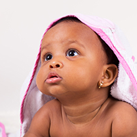 Adorable little african american baby girl looking up