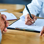 a doctor writing on a notepad