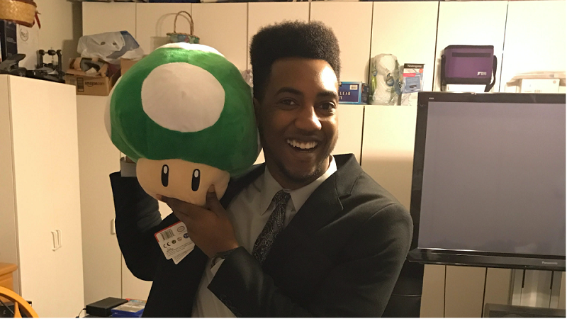 stan gill holding a stuffed mushroom from the game mario