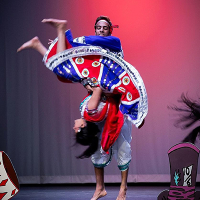 Akshay performing a choreographed flip with his teammate during a team performance in his sophomore year of college
