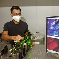 Dushan Wadduwage works with a laser in his Northwest lab where he does research on deep tissue imaging.