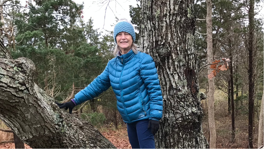 janine leaning against a tree