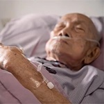 an elderly person lying on a hospital bed