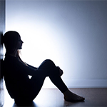 young adult sitting alone in a dark room