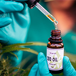 a person holding a dropper of cbd oil