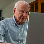 an elderly man using a computer