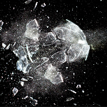A piece of glass being destroyed against a black background