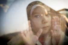 child-looking-thru-window-Adobe-Stock-Jasmin-Merdan