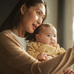 Mother pointing while talking to infant.