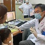 Yilai Shu communicates with a young patient at the Eye & ENT Hospital of Fudan University.