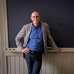 michael pollan leaning against a blackboard