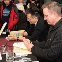 dwayne godwin and jorge cham signing copies of their book.