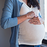 a pregnant woman holding her stomach