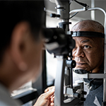ophthalmologist examining older man's eyes