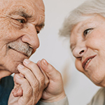 two elderly people lovingly looking at each other