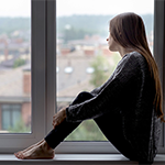 a young woman sitting on a window sill